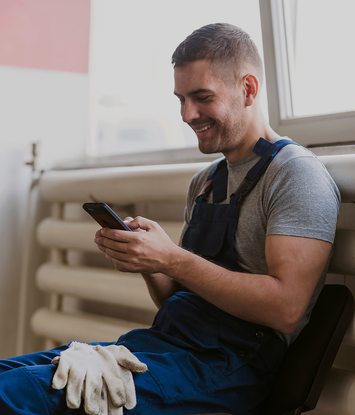 Smilling HVAC checking his phone
